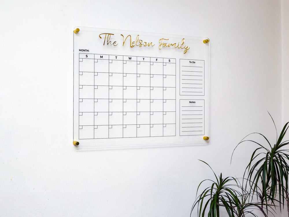 Acrylic wall calendar in a living room with a plant