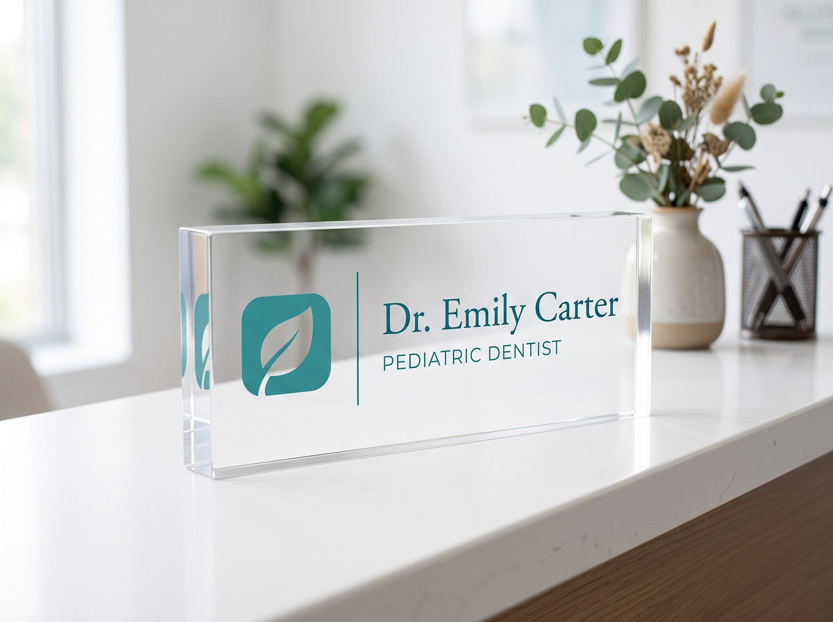 Clear acrylic name plate with logo and doctor name on a clinic reception counter